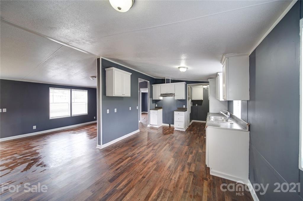 283 Ballard Spring Road, Unit 3276 Morven, NC 28119 - Photo 41 of 48 a kitchen with stainless steel appliances granite countertop a refrigerator microwave and wooden floor
