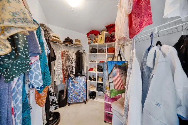 a view of walk in closet with clothes and shoes