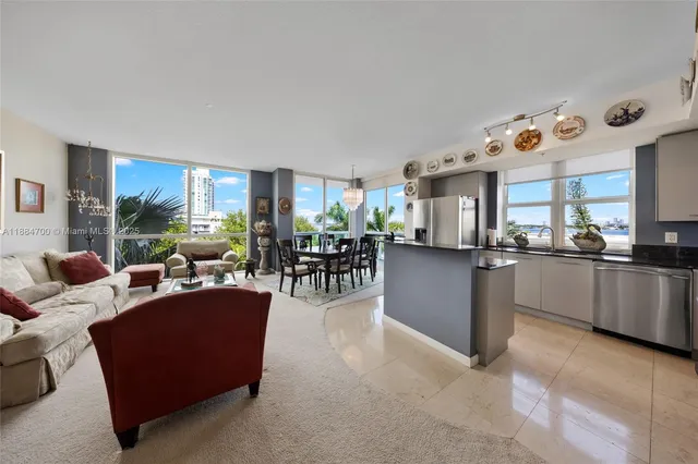 a living room with furniture kitchen area and a window