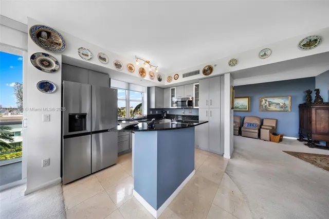 a kitchen with stainless steel appliances granite countertop a refrigerator and a sink
