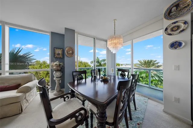 a dining room with furniture a chandelier and window