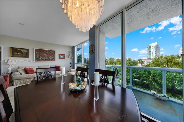a living room with patio furniture and a floor to ceiling window