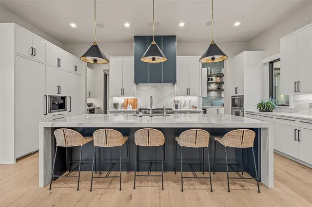 a large kitchen with kitchen island a sink stainless steel appliances and cabinets