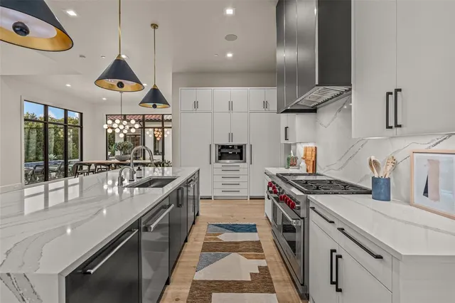 a large kitchen with stainless steel appliances kitchen island granite countertop a sink and a stove