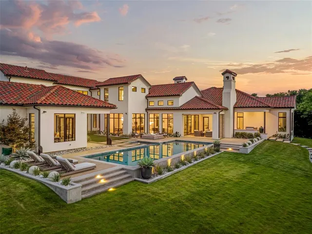 a view of swimming pool with seating area and trees in the background