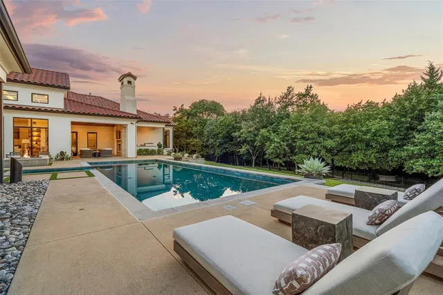 a view of a house with pool and chairs