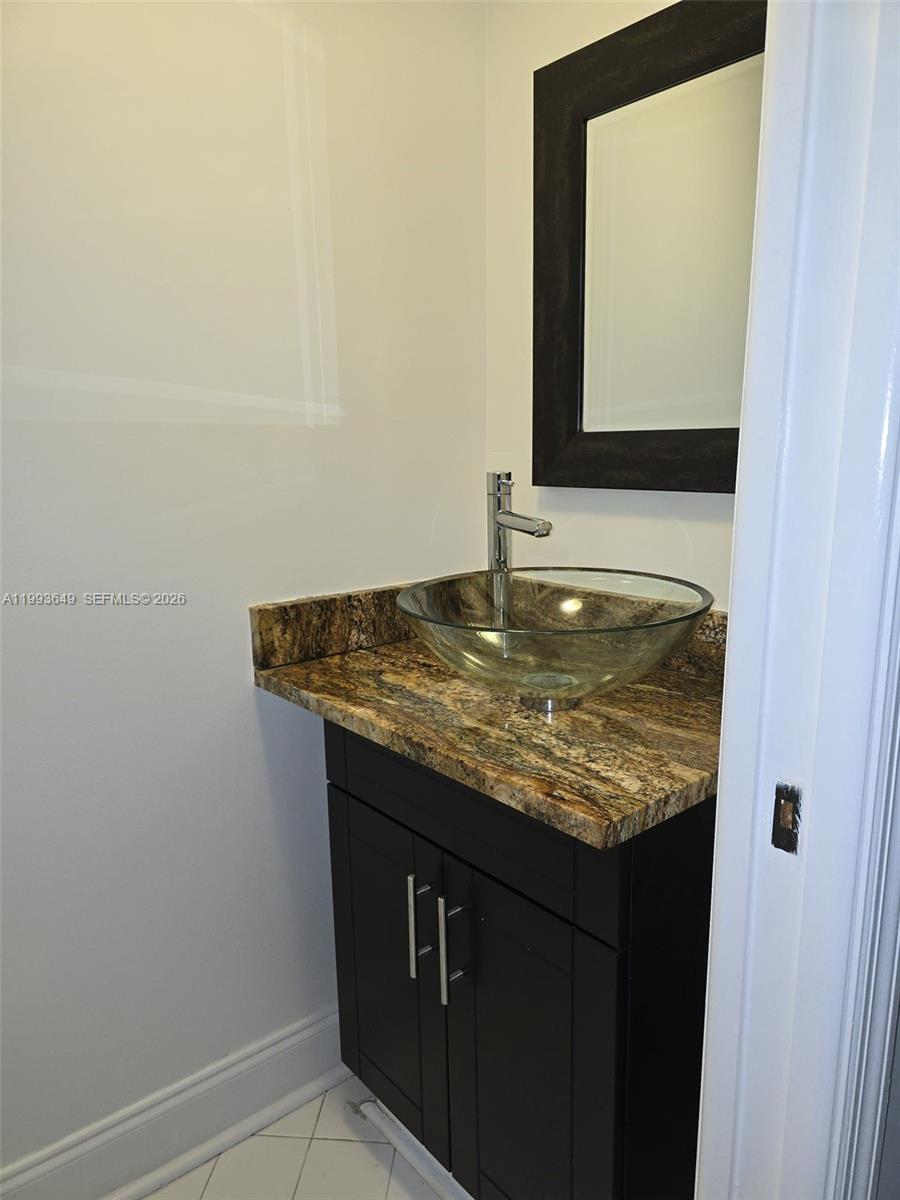 14272 Southwest 121st Place, Unit 9 Miami, FL 33186 - Photo 14 of 17 a bathroom with a granite countertop sink and a mirror