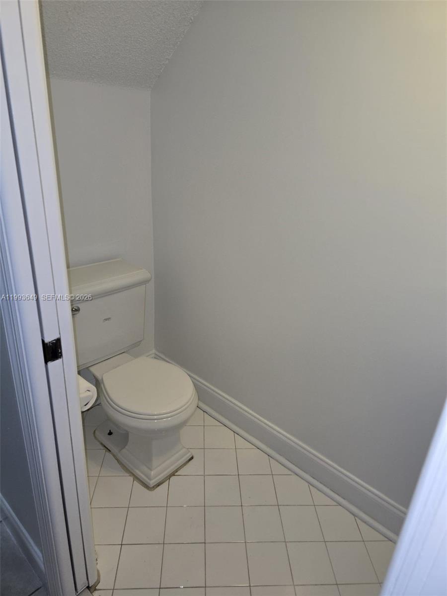 14272 Southwest 121st Place, Unit 9 Miami, FL 33186 - Photo 15 of 17 a white toilet sitting next to a shower