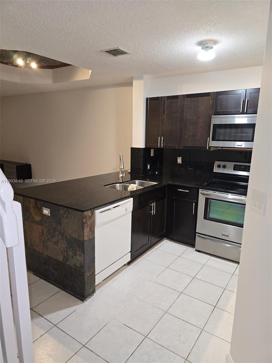 14272 Southwest 121st Place, Unit 9 Miami, FL 33186 - Photo 7 of 17 a kitchen with a sink and cabinets