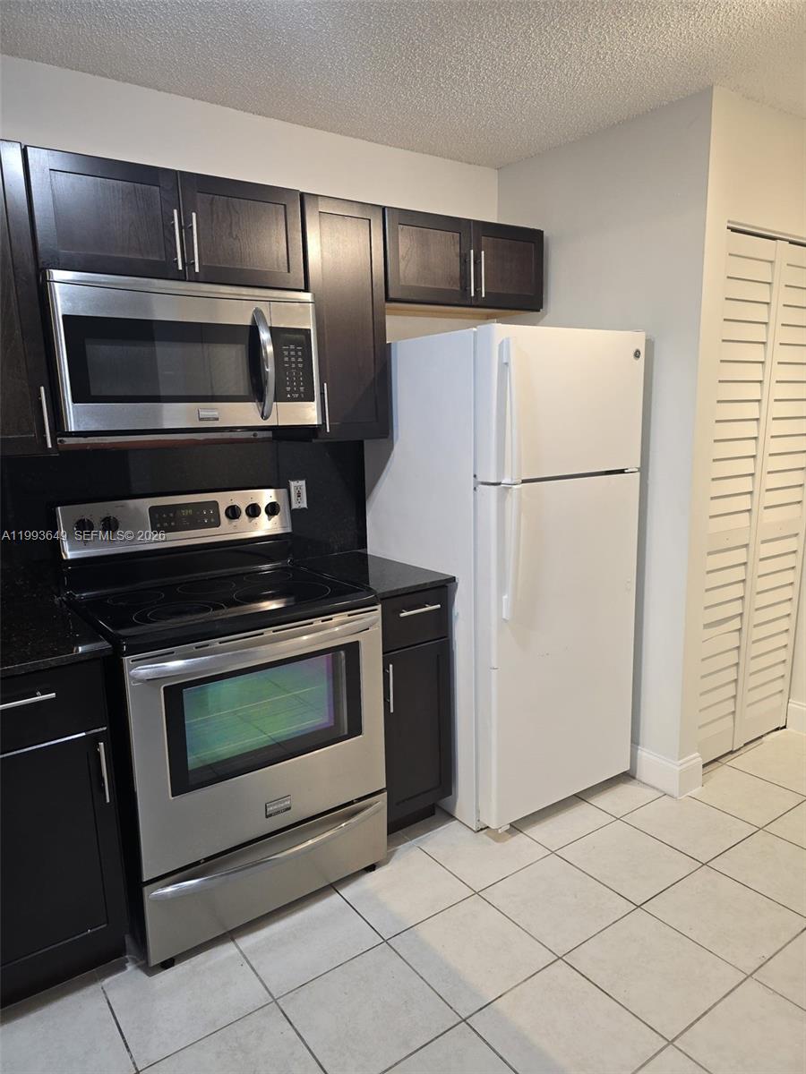 14272 Southwest 121st Place, Unit 9 Miami, FL 33186 - Photo 8 of 17 a kitchen with appliances and cabinets