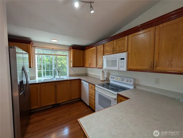 a kitchen with stainless steel appliances granite countertop wooden cabinets a sink and a stove