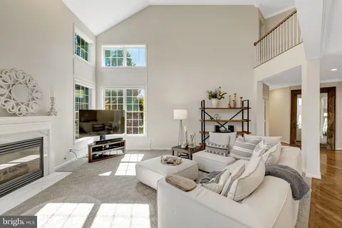a kitchen with stainless steel appliances kitchen island granite countertop a dining table chairs and a refrigerator a sink with wooden floor