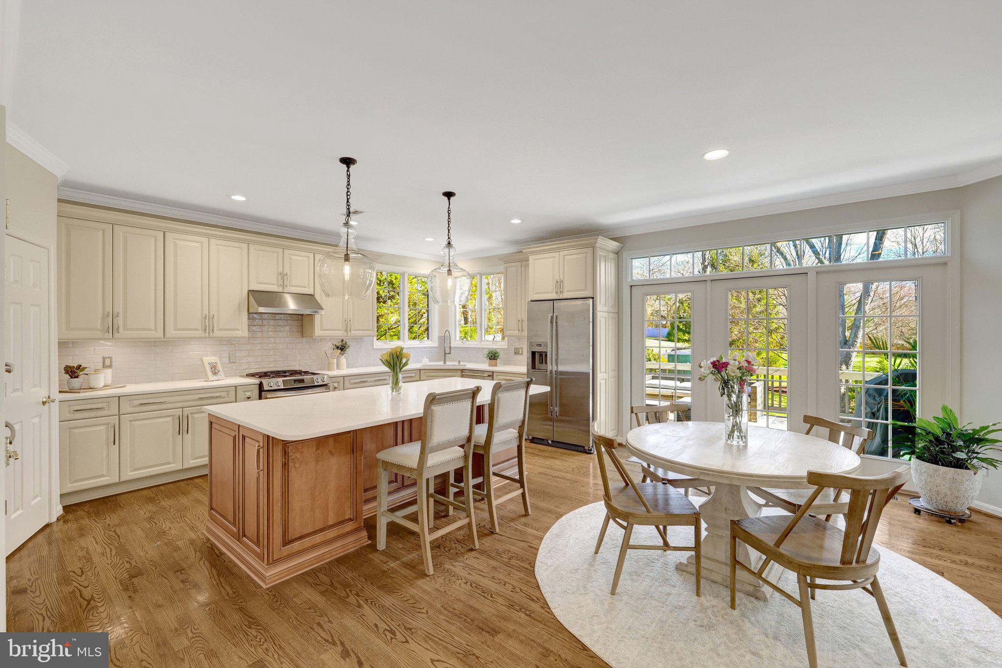1827 Beulah Road Vienna, VA 22182 - Photo 26 of 91 a kitchen with a dining table chairs stove and white cabinets