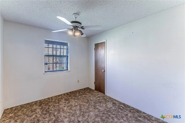 a view of a hallway with a chandelier fan and a window