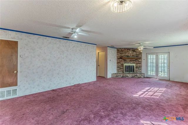 en empty room with windows and ceiling fan