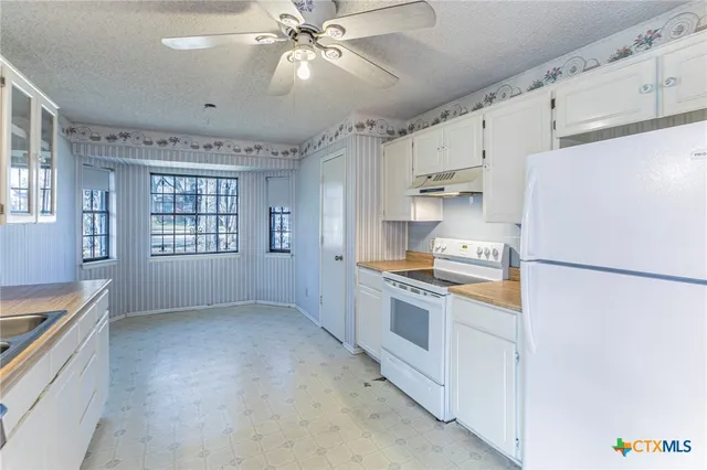 a kitchen with stainless steel appliances a refrigerator a stove a sink a center island and cabinets