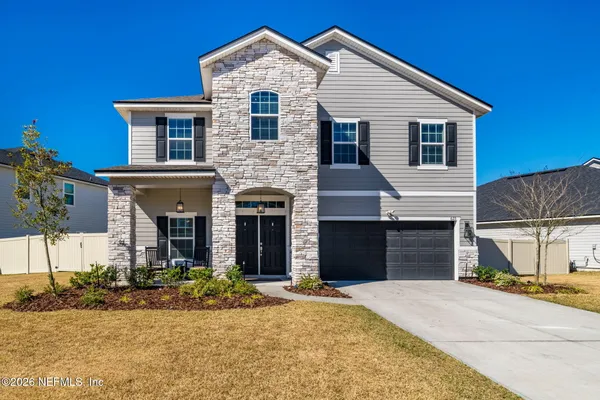 a front view of a house with a yard and garage