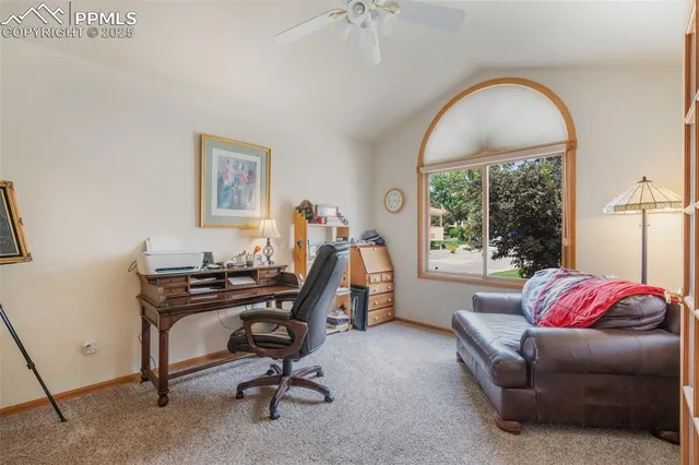 a view of a workspace with furniture and a window