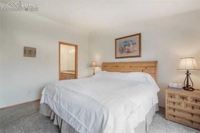 a bedroom with a bed and a lamp on dresser