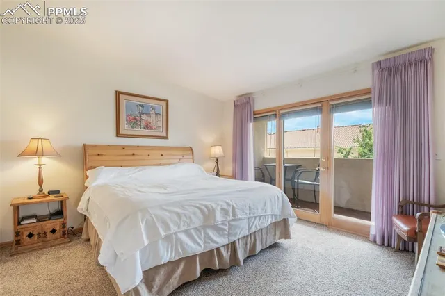 a bedroom with a bed and large windows