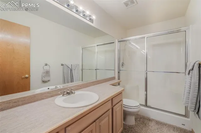 a bathroom with a sink toilet vanity and shower