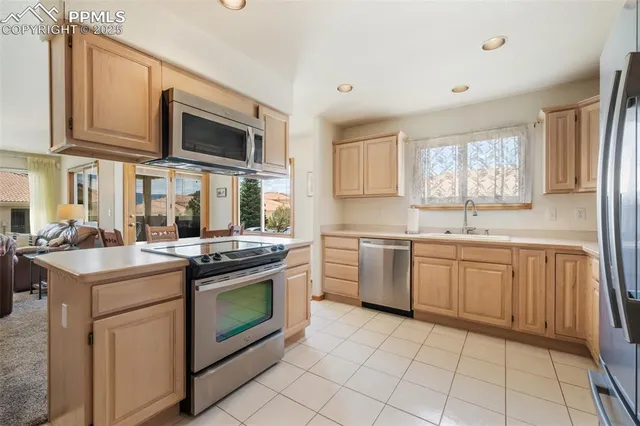 a kitchen with stainless steel appliances granite countertop a stove top oven a sink dishwasher and white cabinets with wooden floor