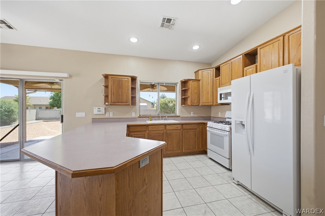 3918 North Eagle Rock Road Kingman, AZ 86409 - Photo 6 of 44 a kitchen with stainless steel appliances granite countertop a refrigerator a sink a stove a microwave and island