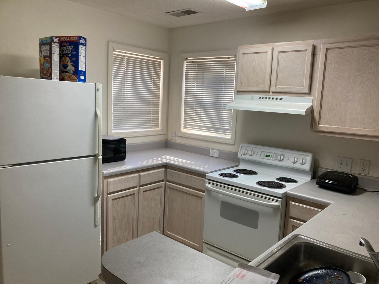 3770 Pardue Woods Place, Unit 102A Raleigh, NC 27603 - Photo 4 of 13 a kitchen with a refrigerator sink and cabinets