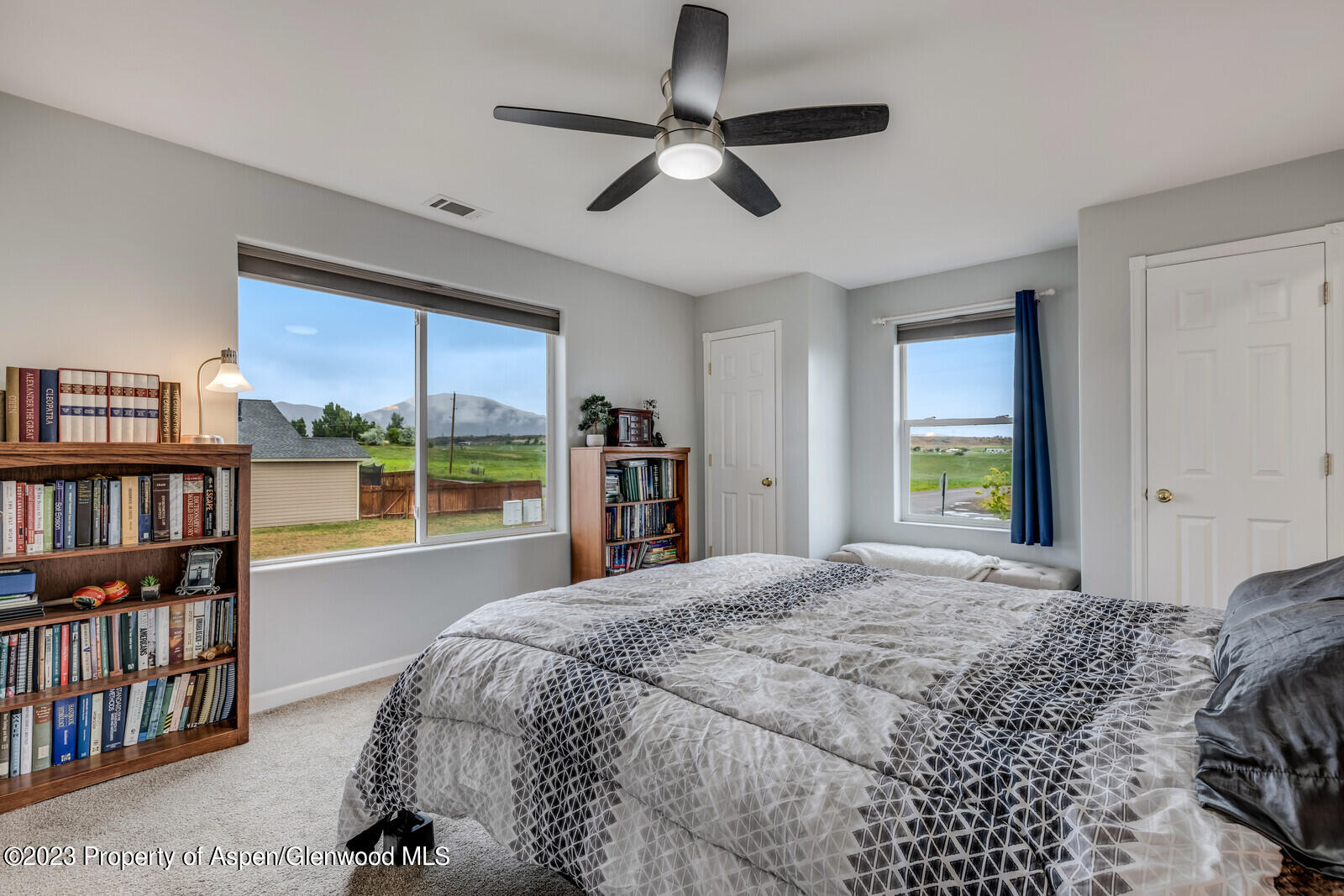 1391 East 17th Street Rifle, CO 81650 - Photo 17 of 36 a bedroom with a bed a large window and a chandelier