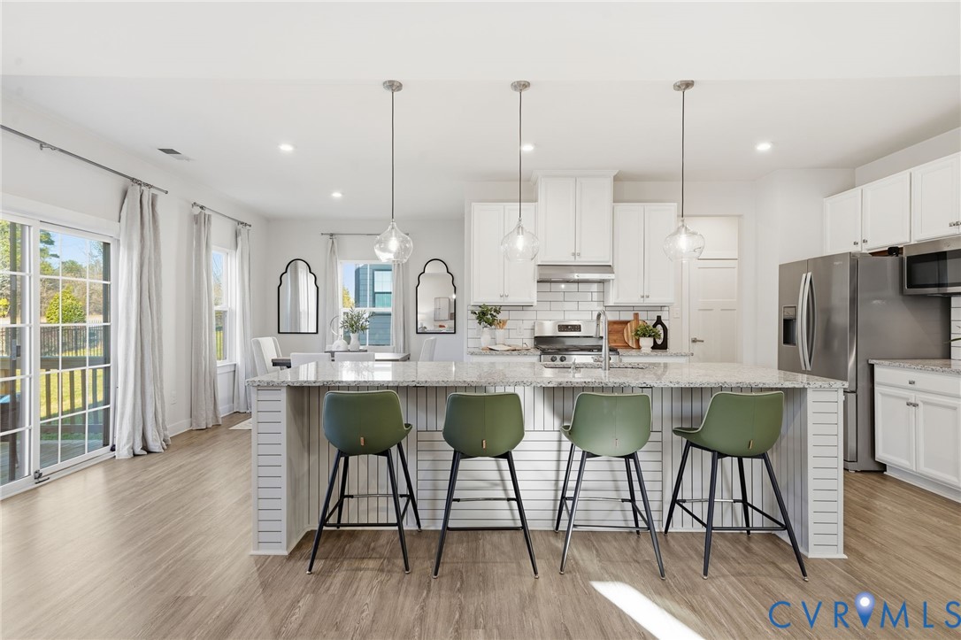 4730 Hepler Ridge Way Glen Allen, VA 23059 - Photo 11 of 39 a kitchen with stainless steel appliances granite countertop a stove a refrigerator a oven a sink with island chairs and wooden floor