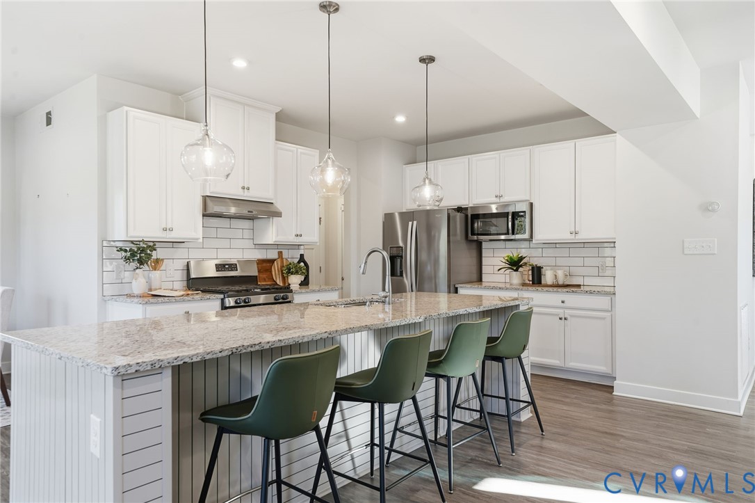 4730 Hepler Ridge Way Glen Allen, VA 23059 - Photo 13 of 39 a kitchen with stainless steel appliances granite countertop a kitchen island a stove a table and chairs in it