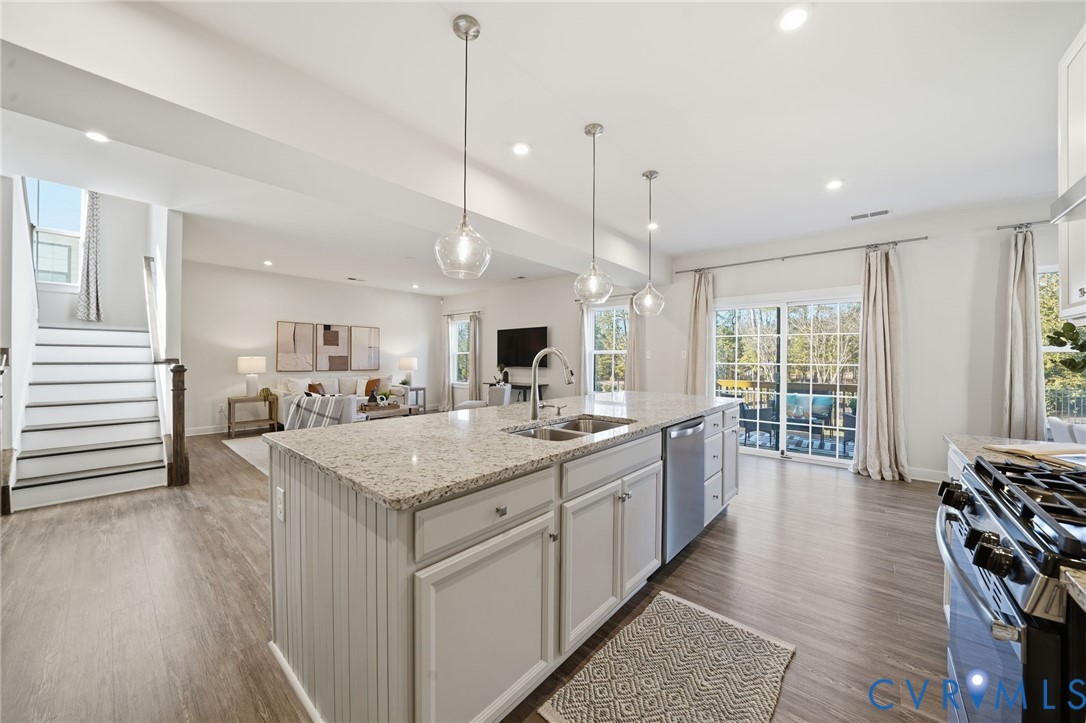 4730 Hepler Ridge Way Glen Allen, VA 23059 - Photo 9 of 39 a large kitchen with kitchen island a stove a sink a dining table and chairs with wooden floor