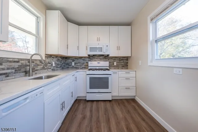 a kitchen with appliances cabinets and a large window