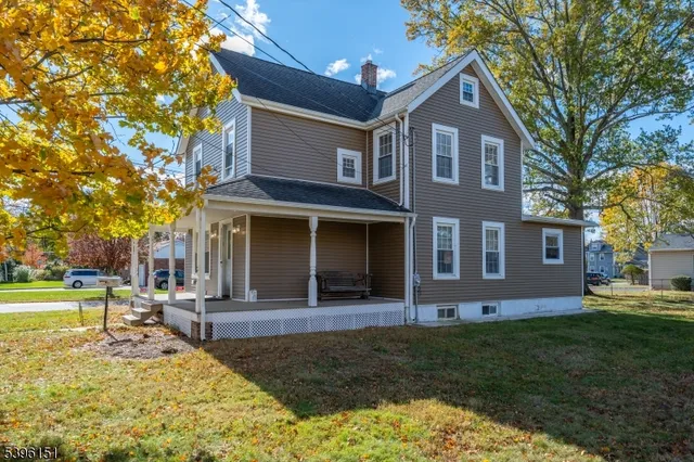 a front view of a house with garden and trees