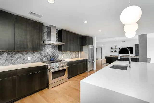 a kitchen with stainless steel appliances kitchen island granite countertop a sink and cabinets