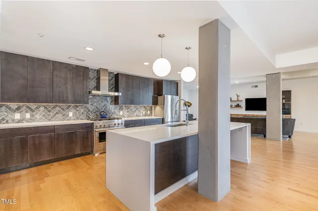 a kitchen with stainless steel appliances granite countertop a sink stove and refrigerator