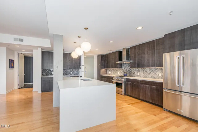 a large kitchen with stainless steel appliances granite countertop a refrigerator and a stove top oven