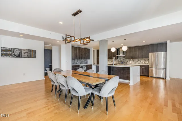 a view of a dining room and livingroom with furniture wooden floor a rug a flat screen tv