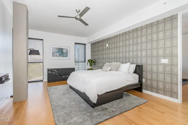 a spacious bedroom with a bed and lamp