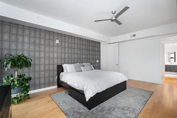 a bedroom with a large bed and a potted plant