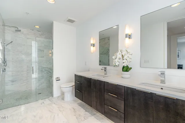a spacious bathroom with a granite countertop sink mirror and shower