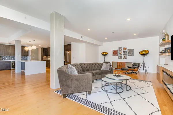 a living room with furniture and a dining table with kitchen view