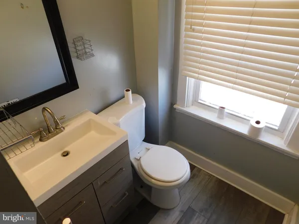 a bathroom with a sink a toilet and a window