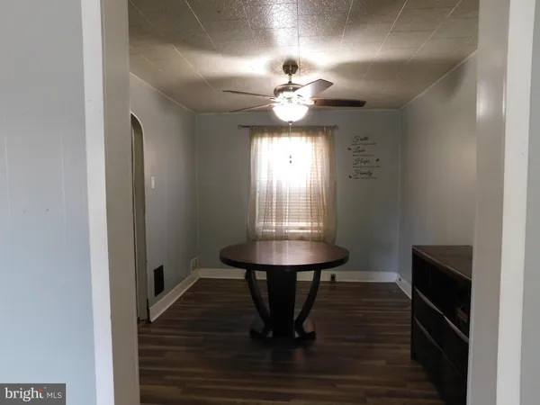a view of a room with a table and chandelier fan