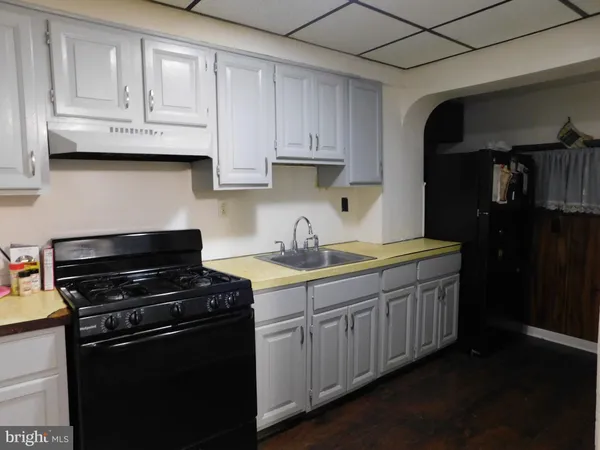 a kitchen with granite countertop white cabinets and black appliances