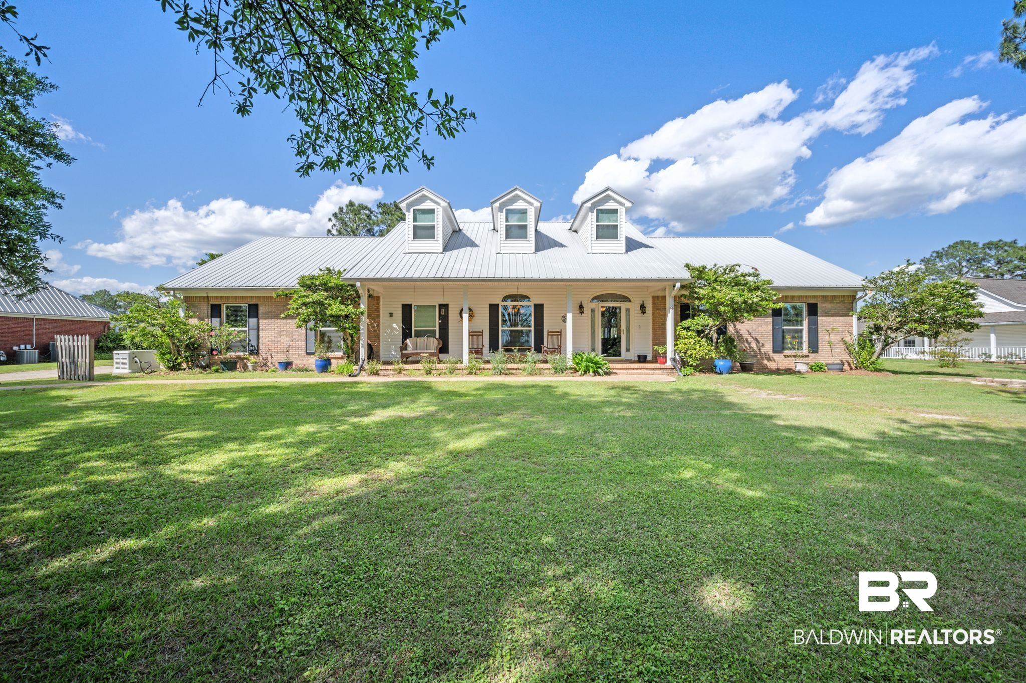 3100 Radcliff Road Saraland, AL 36571 - Photo 1 of 65 Cape cod house featuring a front yard, brick siding, a porch, and metal roof