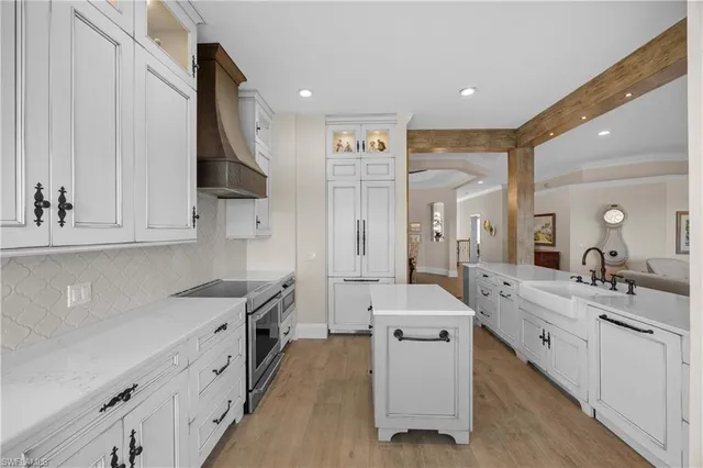 a kitchen with cabinets a sink and a stove with wooden floor