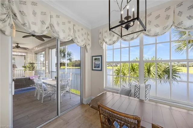 a view of a dining room with furniture one side kitchen view and wooden floor