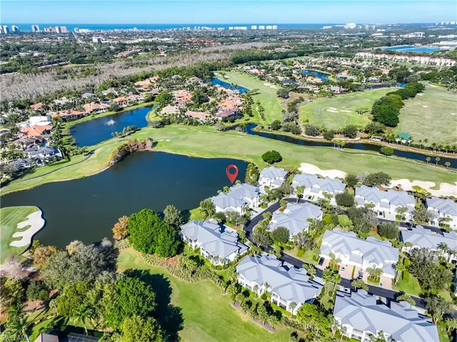 an aerial view of a city with lots of residential buildings ocean and mountain view in back