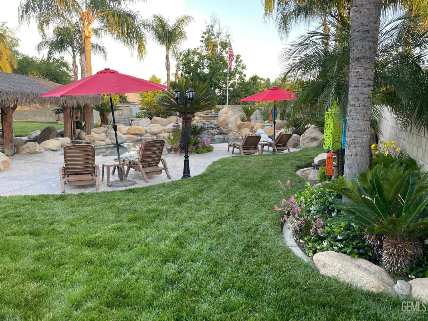 Undisclosed Address Bakersfield, CA 93314 - Photo 21 of 60 a view of a chairs and table under an umbrella in backyard
